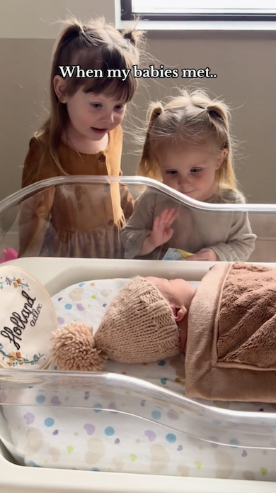 妹に小さく手を振る次女