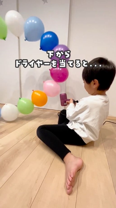 風船にドライヤーの風をあてる画像