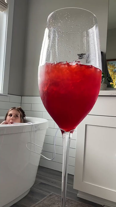 お風呂で超巨大グラスからジュースを飲むところ