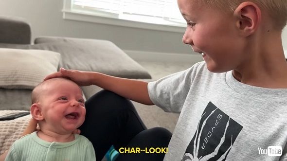 赤ちゃんのいとこに笑ってもらえて大喜びする男の子