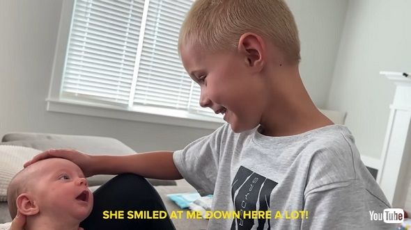 赤ちゃんのいとこに笑ってもらえて大喜びする男の子