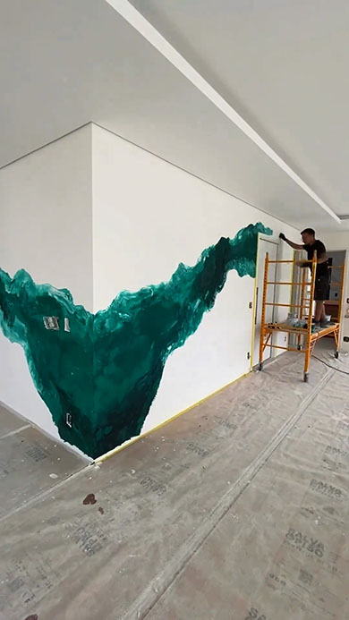 塗装職人が壁を大理石に・緑の柄を描いているところ
