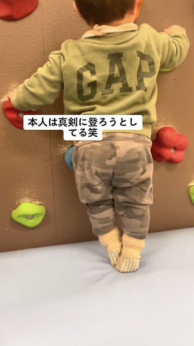 壁を登ろうとする1歳児