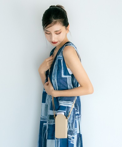 Wpc.の新作日傘「遮光ポシェットタイニー」を肩からかけた様子