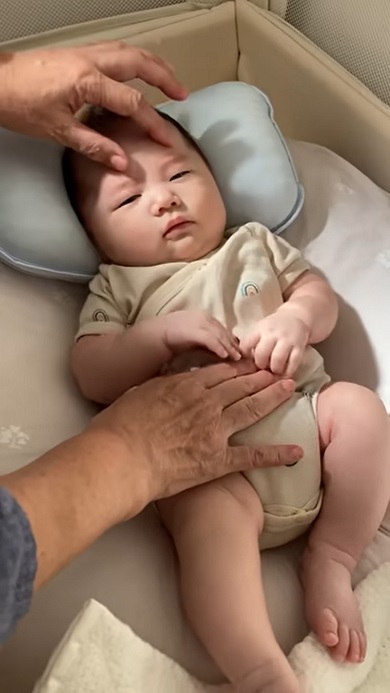 眠くないことに気付き寝かしつけようとする親に目で訴える赤ちゃん