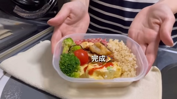 焼いたむね肉を「枝豆入りオムレツ」などと一緒に容器へ詰め込む