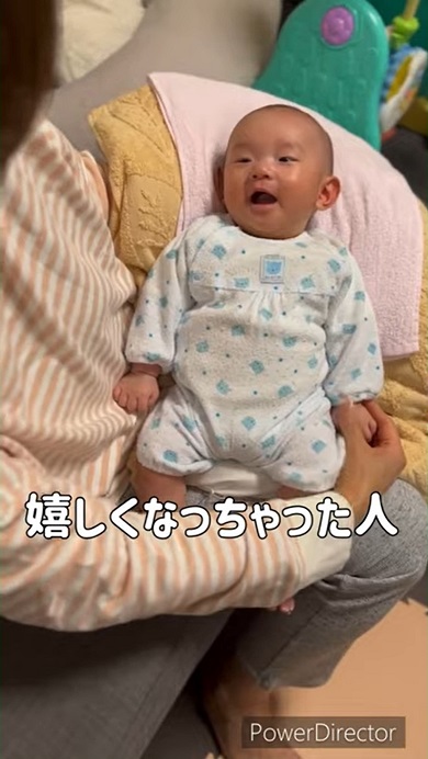おばあちゃんに手をさすってもらいうれしくなった赤ちゃん