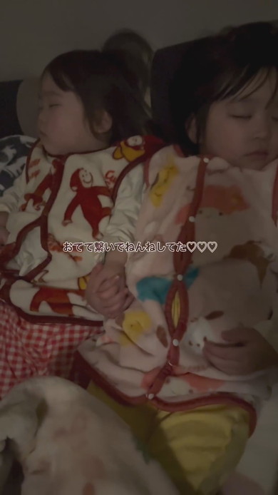 手をつないで寝る幼い姉妹