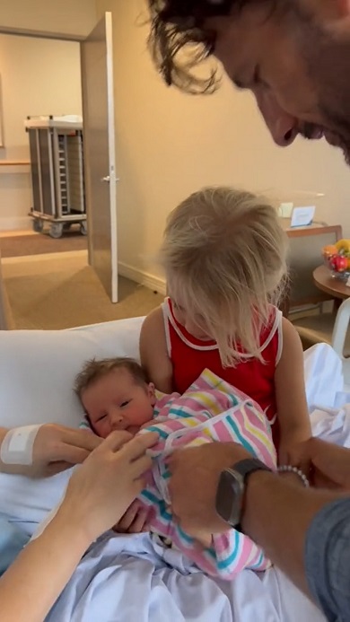 病院で生まれたばかりの妹を抱っこする女の子
