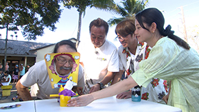 パイ投げのおもちゃを出会った人と遊ぶ3人