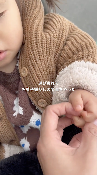 眠くてもお菓子を手放さない1歳娘