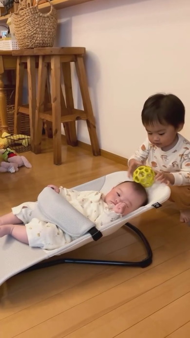 赤ちゃんの周りにおもちゃを置くお兄ちゃん