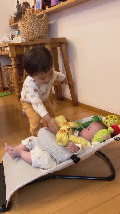 赤ちゃんの周りにおもちゃを置くお兄ちゃん