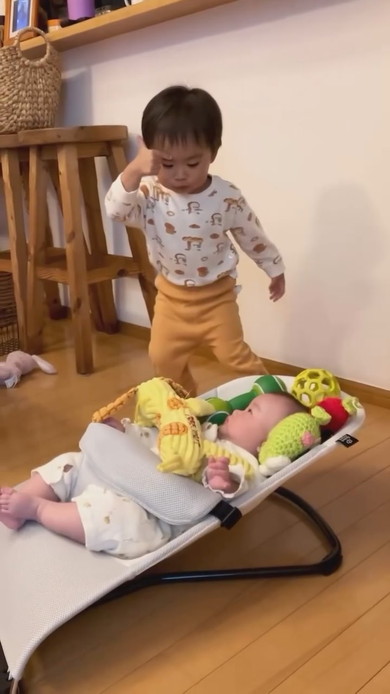 赤ちゃんの周りにおもちゃを置くお兄ちゃん