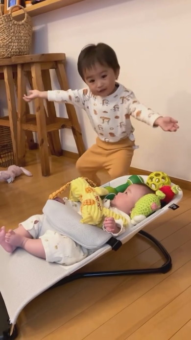 赤ちゃんの周りにおもちゃを置くお兄ちゃん