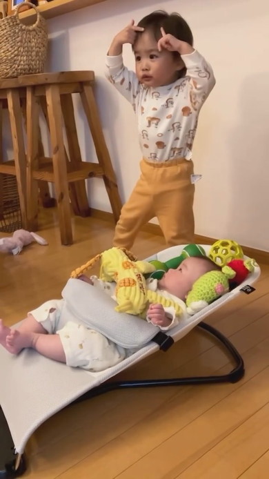 赤ちゃんの周りにおもちゃを置くお兄ちゃん