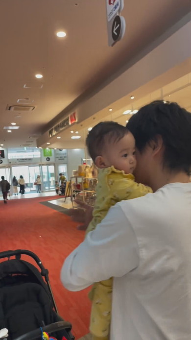 巨大な熊の置物に触れてびっくりする赤ちゃん