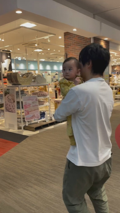 巨大な熊の置物に触れてびっくりする赤ちゃん