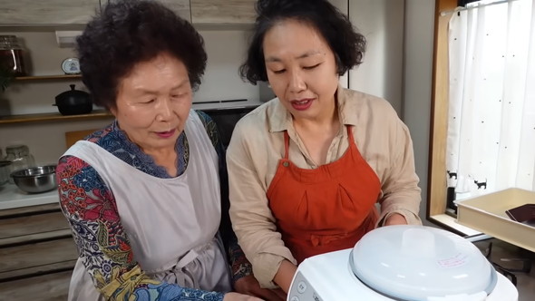 韓国の母と一緒に自動餅つき機を使ってぜんざい作りをする光景