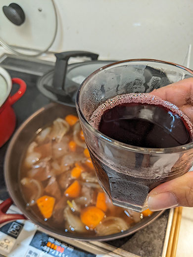牛すじの煮込みを作りながら赤ワインを飲むところ