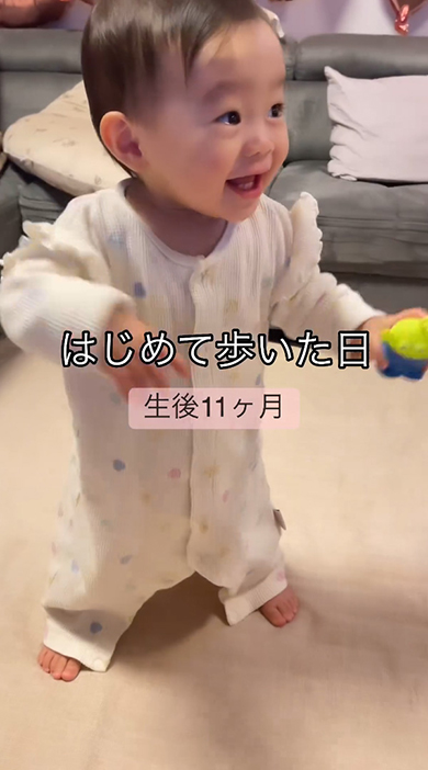 右を見ながら手を上げる赤ちゃん