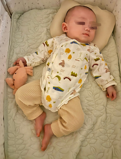 ぬいぐるみをつかんで寝る赤ちゃん