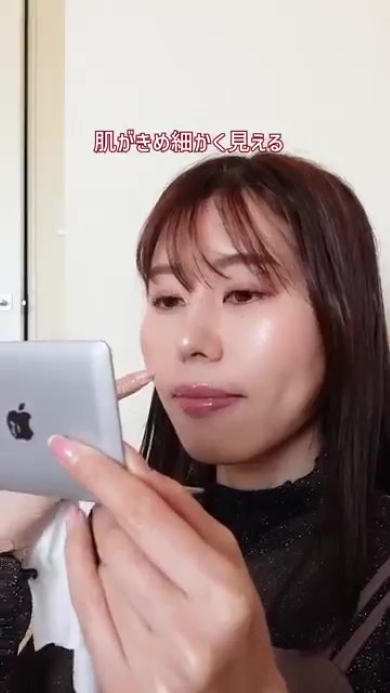 鏡を見てメークをする女性