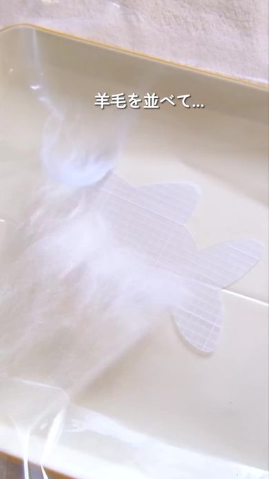羊毛に水とせっけんを加えてサメの形をしたポーチを作る様子