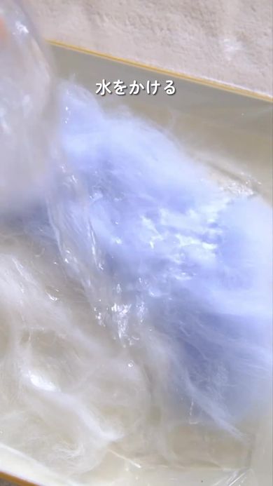 羊毛に水とせっけんを加えてサメの形をしたポーチを作る様子