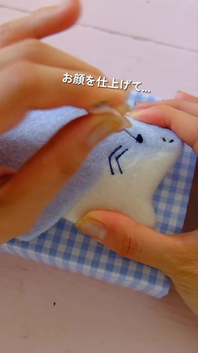 羊毛に水とせっけんを加えてサメの形をしたポーチを作る様子