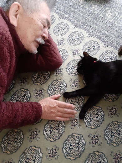 お父さんと横になる黒猫ちゃん