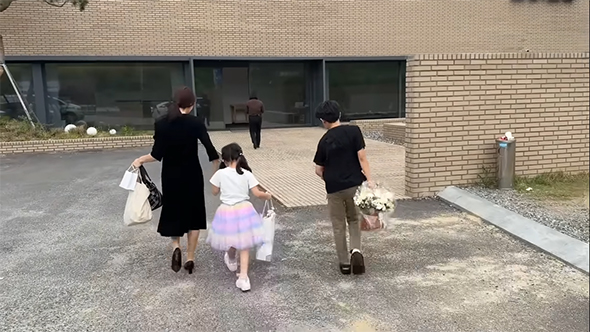 葬儀に向かう一家の背中