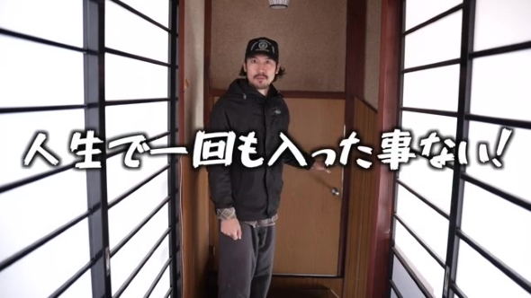 部屋の前に立つ男性