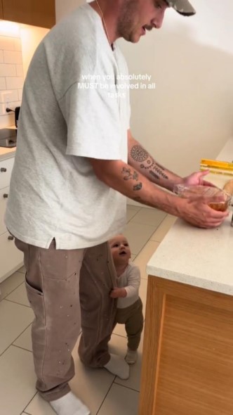 料理中の父親にしがみつく子ども