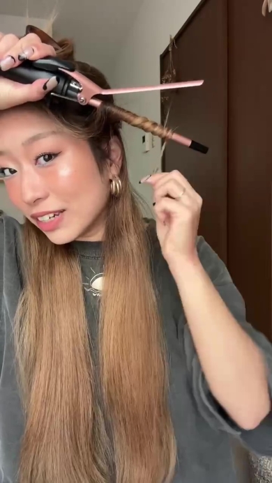 髪の毛を巻く女性