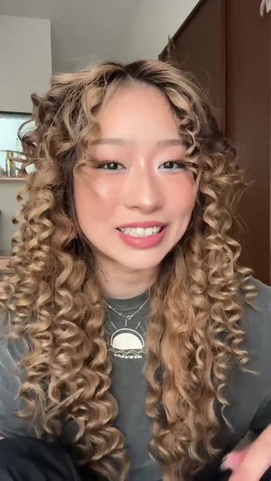 髪の毛を巻き終わった女性