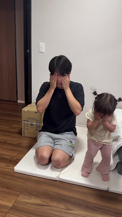 パパの隣で目を隠す娘