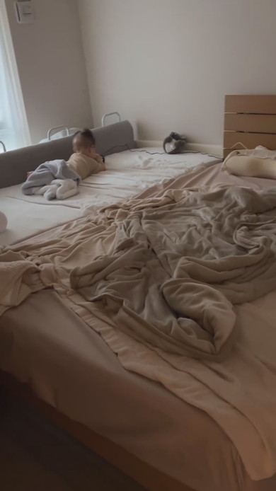 ベッドで腹ばいになっている赤ちゃん