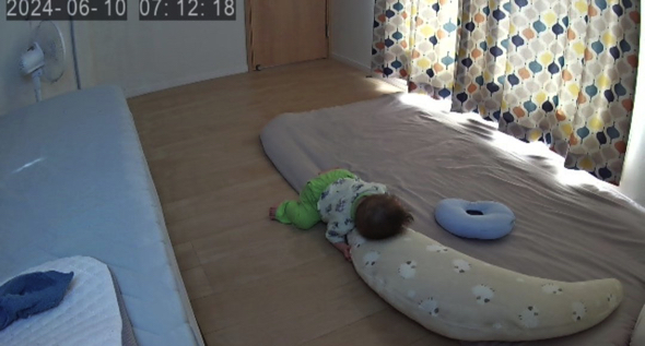 抱き枕を抱えて爆睡する赤ちゃん