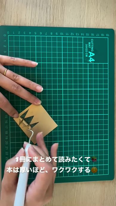 1冊のハードカバーの本にまとめるためカバーの飾りを切り出す