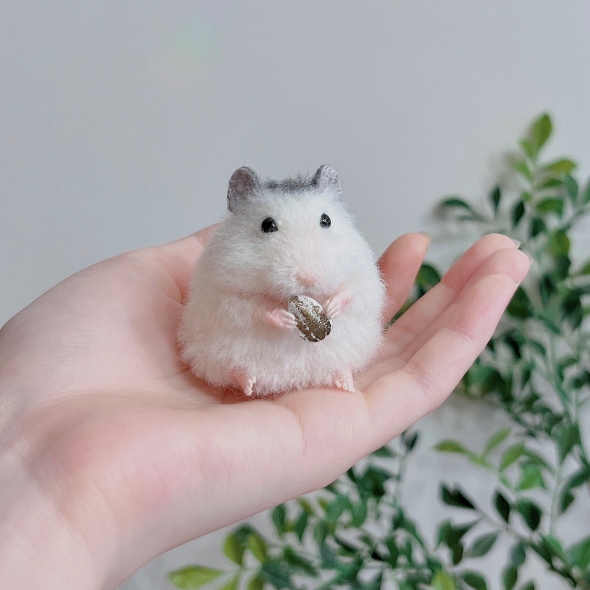 ひまわりの種を持つハムスター