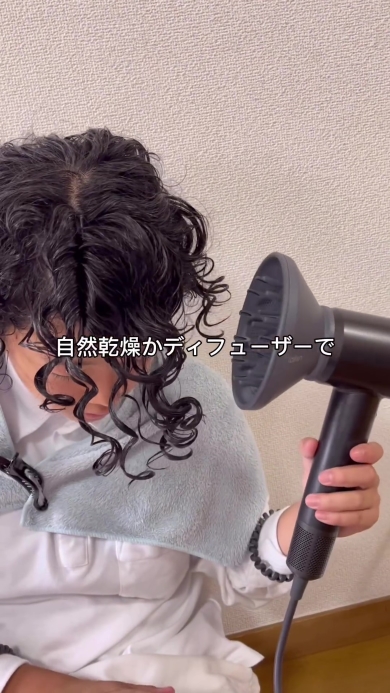 ディフューザーで髪を乾かす女の子