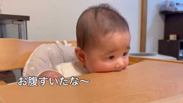 テーブルを口にくわえる赤ちゃん
