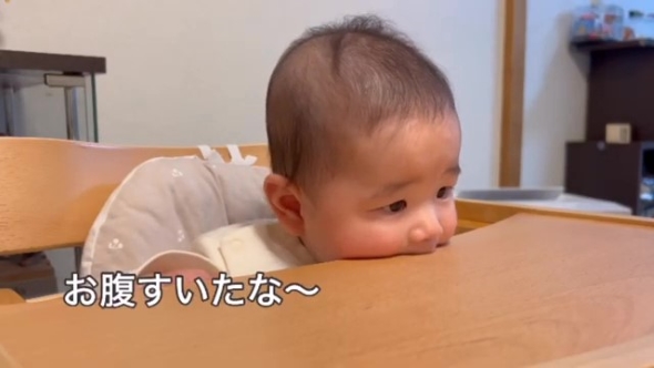 テーブルを口にくわえる赤ちゃん