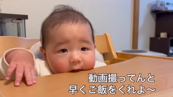テーブルを口にくわえる赤ちゃん