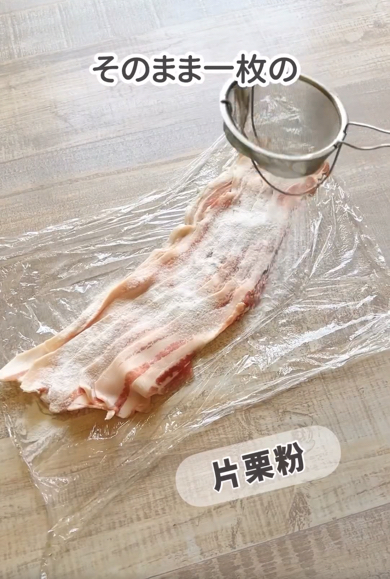 ラップの上に豚バラ薄切り肉をのせ、片栗粉をまぶします
