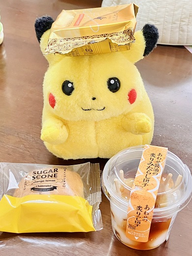 お菓子を前方と頭部の上に置いたピカチュウ