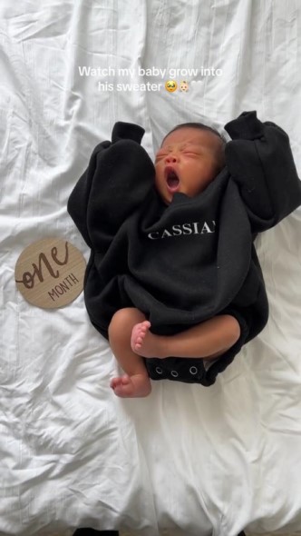 ぶかぶかな服を着る生後1カ月の赤ちゃん