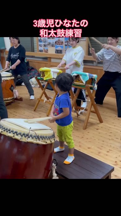 大人と一緒に和太鼓の練習をする3歳の男の子