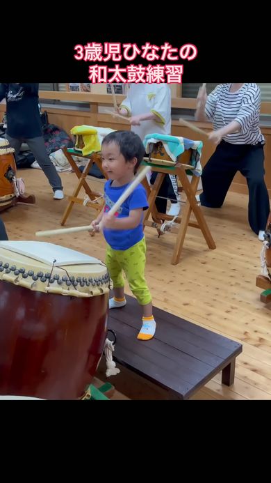 大人と一緒に和太鼓の練習をする3歳の男の子